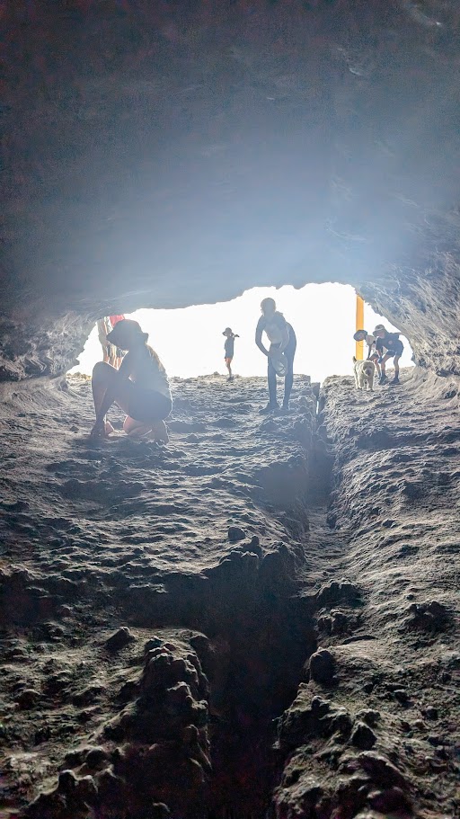 Silhouetted figures explore the dark interior of Gosangs Tunnel in Jervis Bay.