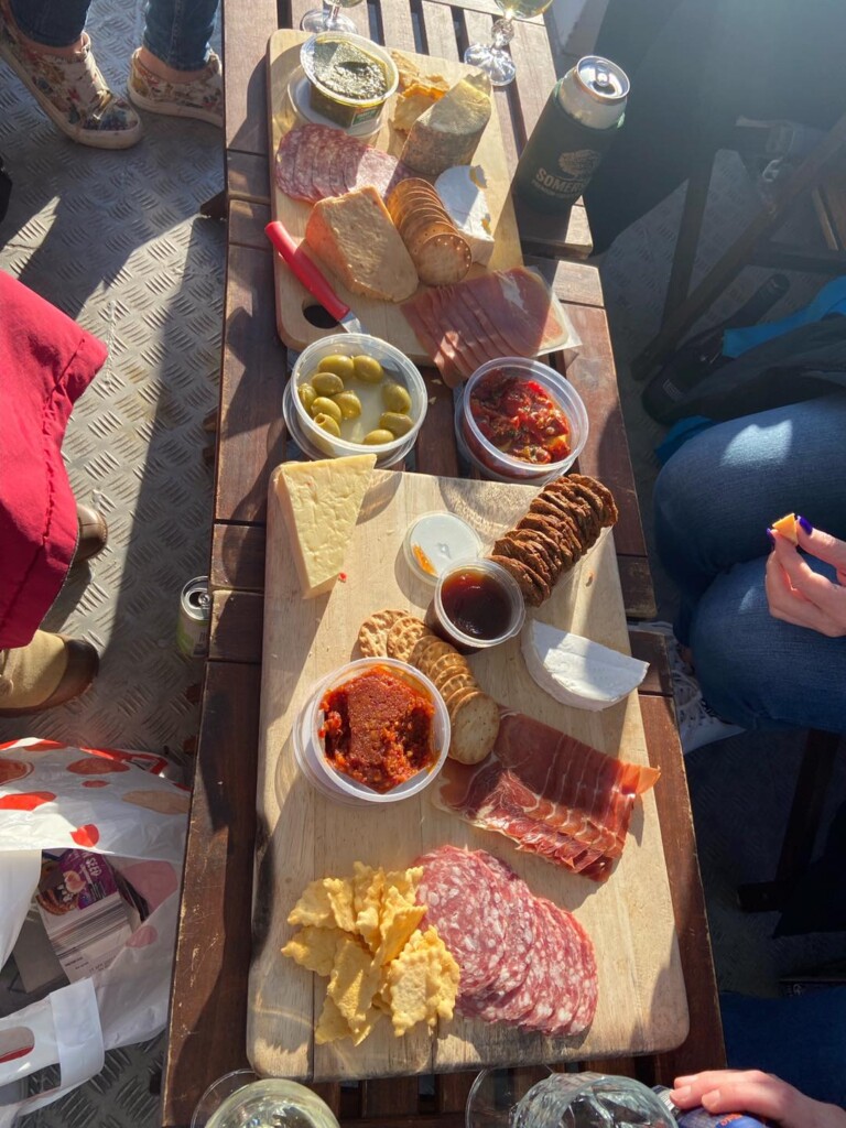 A gourmet charcuterie board with cheeses, olives, and meats served on a boat cruise in Huskisson.