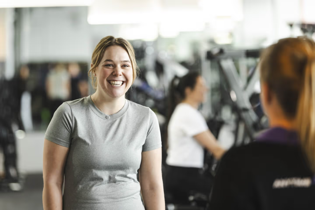 Friendly gym coach welcoming a new member during a fitness consultation at Anytime Fitness Vincentia.