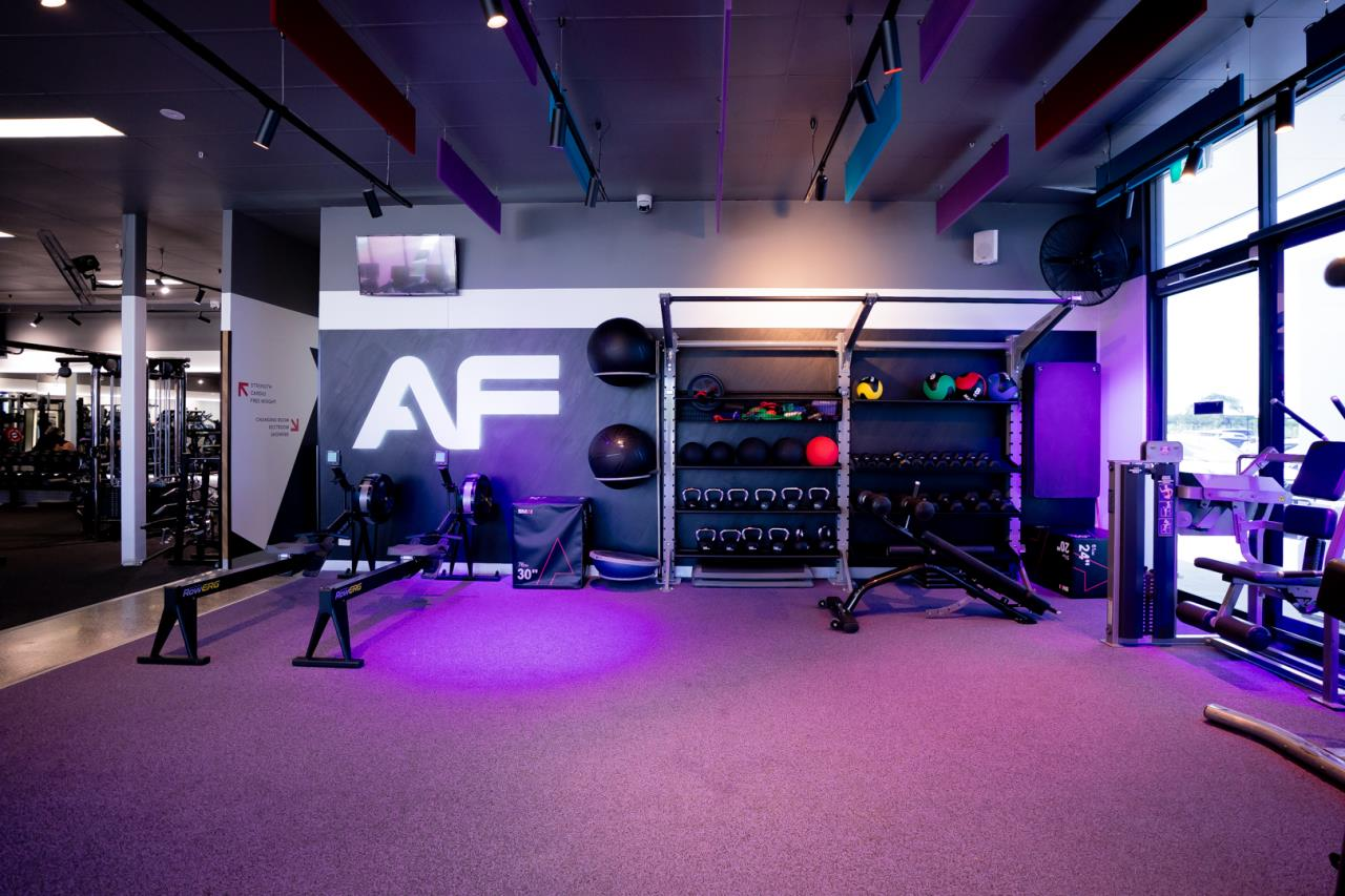 Functional training zone with kettlebells, rowing machines, medicine balls, and open workout space.