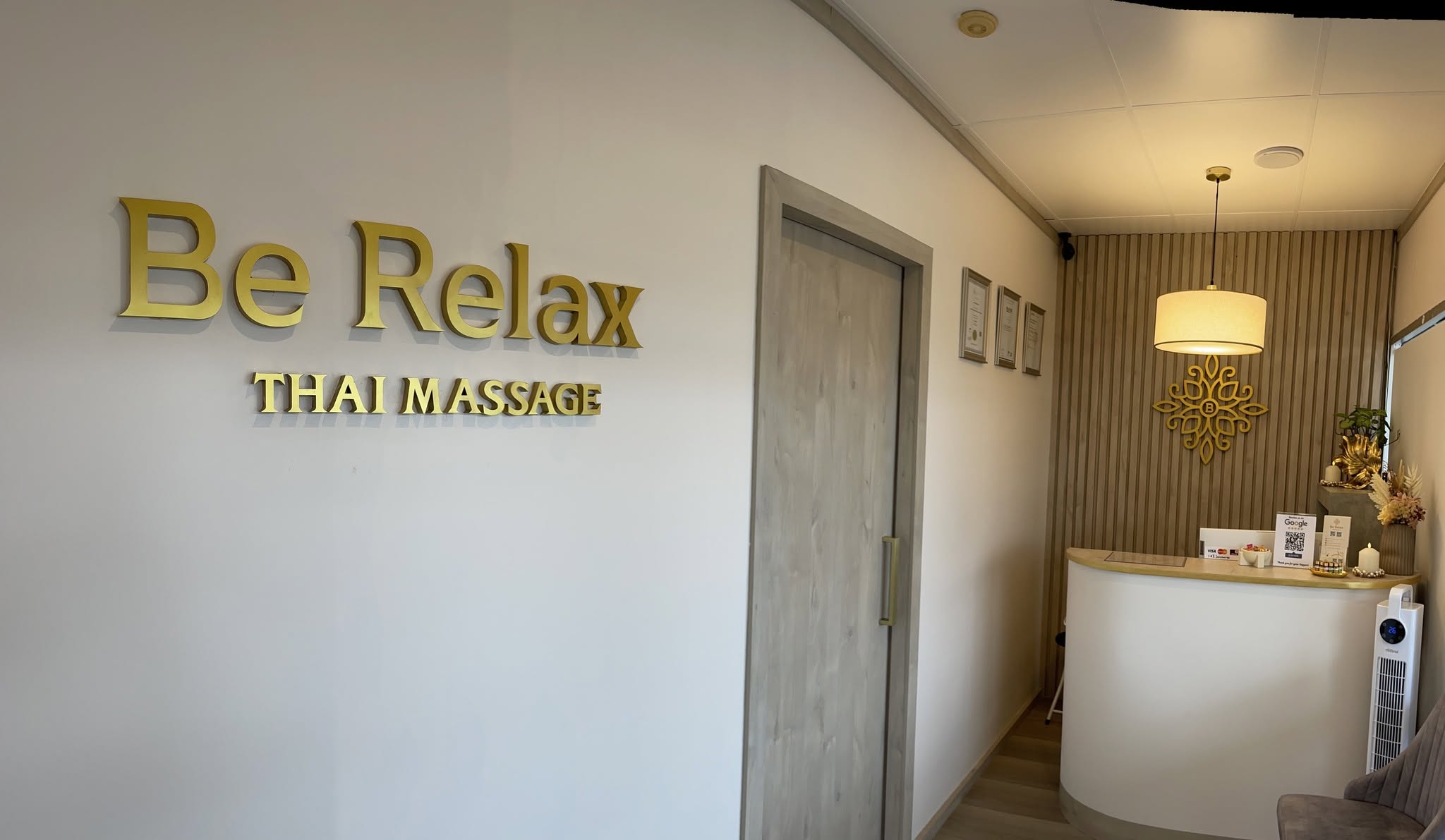 Reception area at Be Relax Thai Massage with branded wall sign and welcoming interior