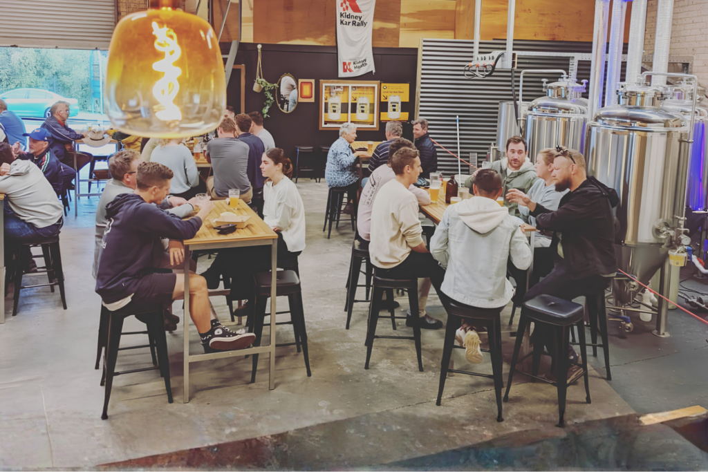 Visitors enjoying craft beer and socialising inside South Yeast Brewing's industrial-style taproom in Nowra, NSW.